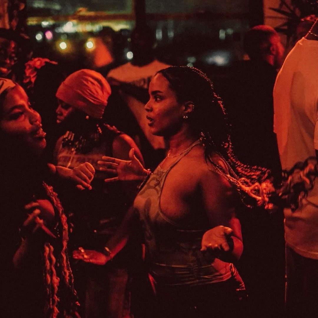 Crowd dancing under red lights at night